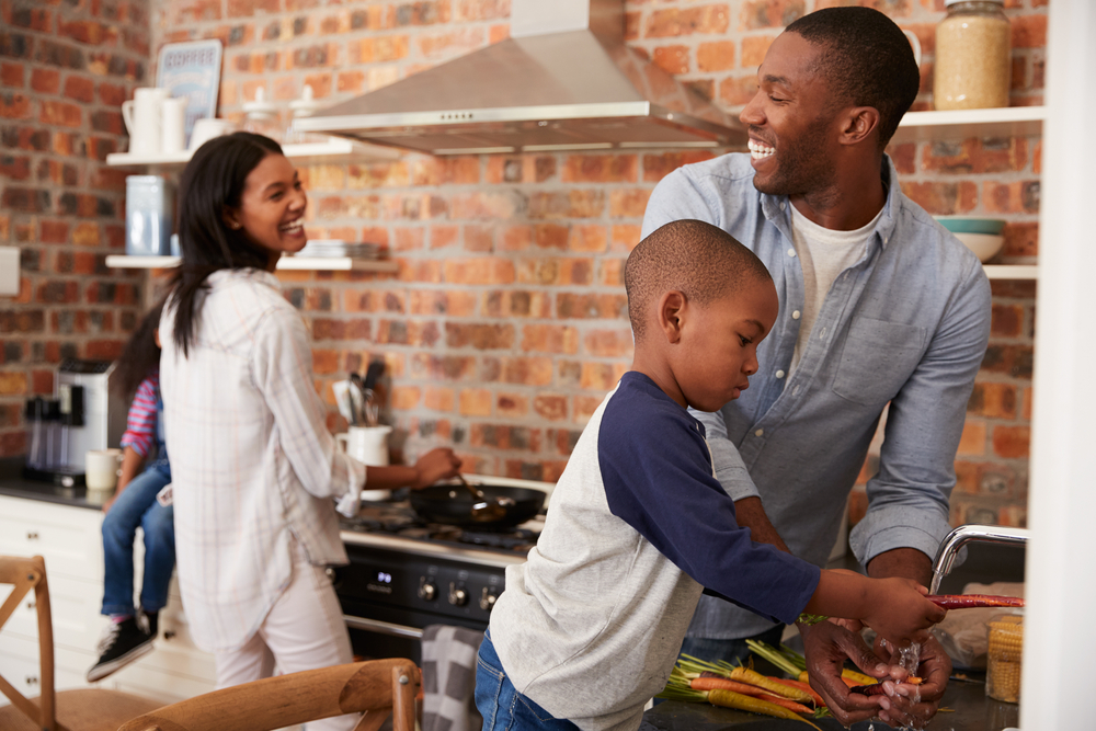 children helping parents prepare dinner in kitchen